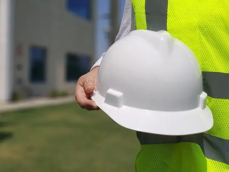 Image of a man holding a hard hat relating to construction site safety